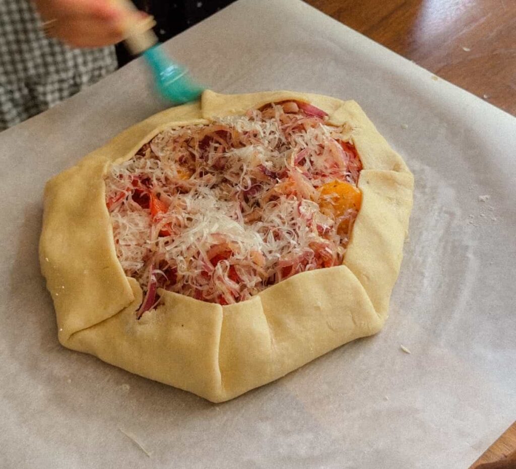 Homemade pie crust folded around tomato galette filling