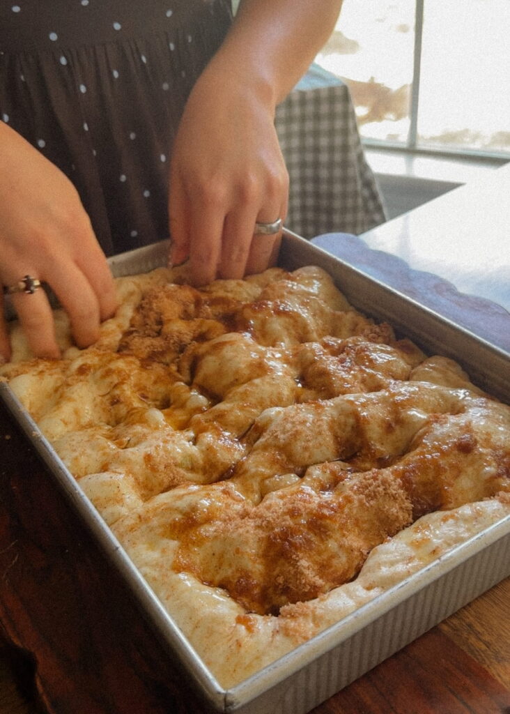 Cinnamon sugar being worked into sourdough focaccia